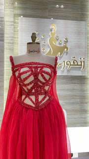 A soft pink, off-the-shoulder dress with delicate lace details, perfect for an engagement party.